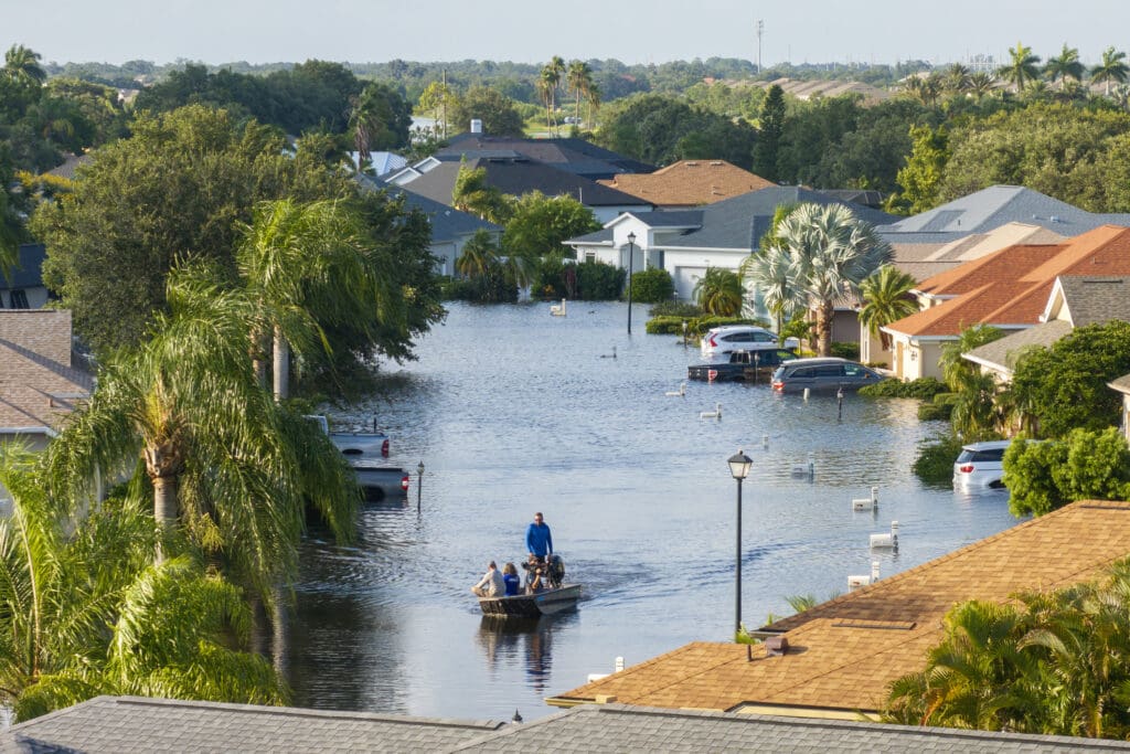People navigating flood in small boat